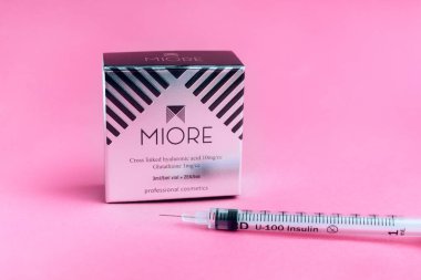 Yüzün biyo-evrimleşmesi için ilacın ambalajı ve pembe arka planda bir şırınga. Kozmetoloji ve cilt bakımı Yaremche, Bukovel, Ukrayna - 10 Ocak 2022