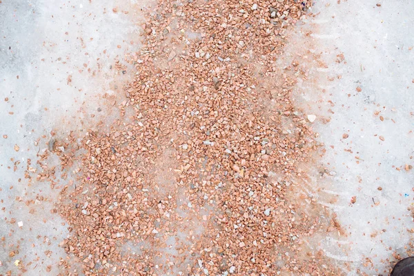 Gångväg beströdd med salt och sandblandningar. Avfrostningskemikalier på trottoaren. Förhindra halka på vägen med sand och reagens - tekniskt salt. Isväg och risk för skador på hal väg — Stockfoto