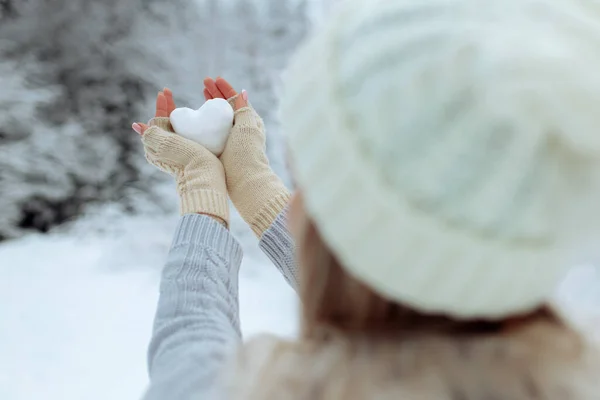 Lubię zimę. Portret szczęśliwej młodej dziewczyny trzymającej w ręku zaśnieżone serce w okresie zimowym. Walentynki. — Zdjęcie stockowe