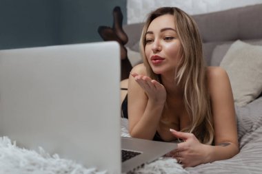Güzel, genç bir kız webcam çekiyor, kameraya bir öpücük yolluyor, manken olarak çalışıyor. İnternette flört etme, internette seks..