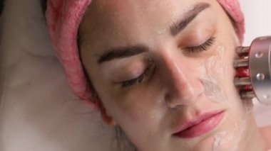 Kozmetik uzmanı biyokaldırma işlemi yapıyor. Cildin gençleşmesi, yaşlanmayı önlemesi, kadının çekici bir yüz bakımı görmesi. Modern klinikte donanım kozmetolojisi. 4k video