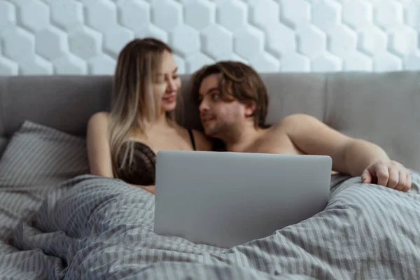 Pareja viendo película porno sobre portátil en el dormitorio —  Fotos de Stock