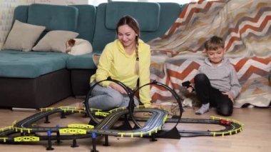 Anne ve küçük oğlu evde halıda yarış oynuyor, eğleniyor ve sarılıyorlar. Bekar bir anne oğlunu araba oynayarak büyütür.