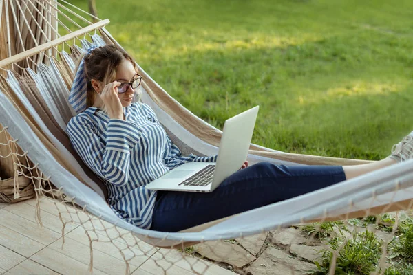 Jonge Mooie Vrouw Ligt Een Hangmat Met Een Laptop Glazen — Stockfoto