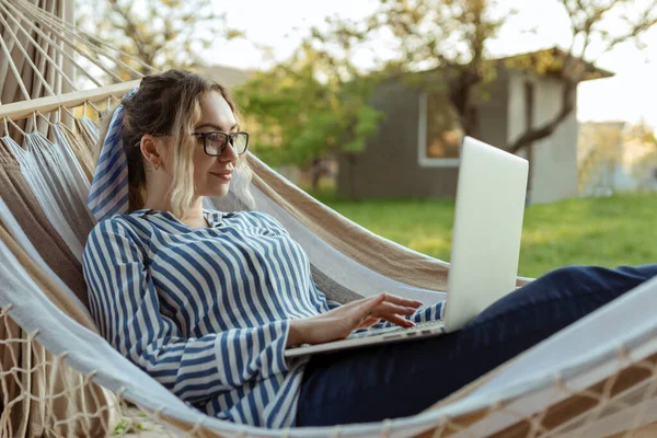 Jonge Mooie Vrouw Ligt Een Hangmat Met Een Laptop Glazen — Stockfoto