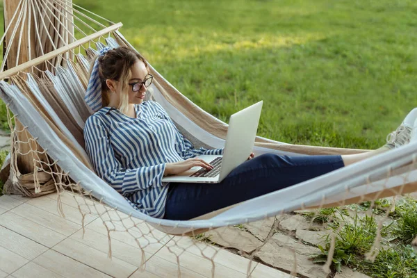 Junge Schöne Frau Liegt Einer Hängematte Mit Laptop Brille Draußen — Stockfoto