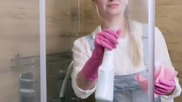 Μια Όμορφη Νοικοκυρά Καθαρίζει Ποτήρι Της Καμπίνας Ντους Από Πλάκα — Αρχείο Βίντεο