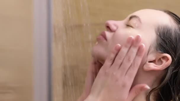 正在洗澡的女人享受着泼洒在她身上的水 闭着眼睛不让她放松 — 图库视频影像