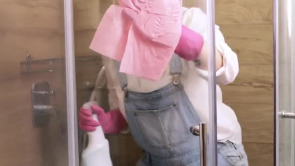美しい主婦がプラークからシャワーキャビンのガラスをきれいにします 清掃サービス又はメイド — ストック動画