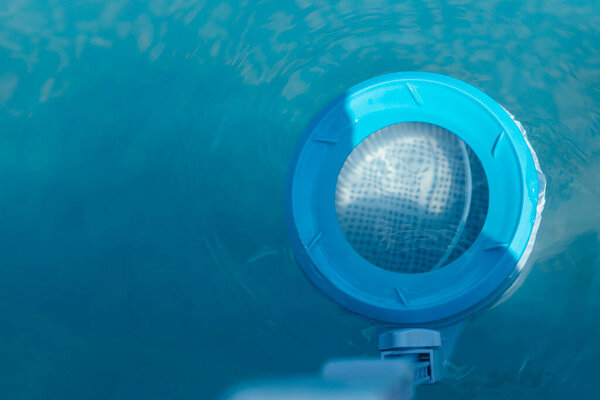 Вид сверху на лыжи для очистки бассейна в чистой воде. Крупный план скиммера, установленного на раме бассейна. 