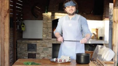 Önlüklü bir adam et parçalarını şişe bağlar ve şöminenin yanında kebap yapar. Gürcistan 'ın ulusal yemeği. 