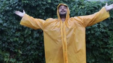 Adam yağmur için Tanrı 'ya şükrediyor. Yağmurluk giyen bir adam sağanakta sevinir. Kuraklık ve iklim değişikliği. 