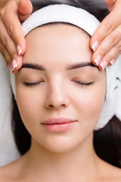 Professional anti-aging facial massage. Action. Relaxing facial treatment at Spa. Relaxing and rejuvenating facial massage for women.