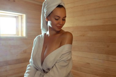 Beautiful young woman relaxing in Finnish sauna. 