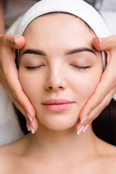 Professional anti-aging facial massage. Action. Relaxing facial treatment at Spa. Relaxing and rejuvenating facial massage for women.