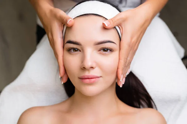 Professional anti-aging facial massage. Action. Relaxing facial treatment at Spa. Relaxing and rejuvenating facial massage for women.