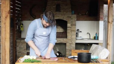 Neşeli adam caddede mangal için et kesiyor. Bahçe partisi. 