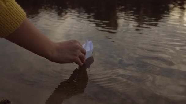 把纸船放在水里 快乐的家庭幻想小孩梦想的概念 玩纸船 一只手在池塘里的公园里划船 — 图库视频影像