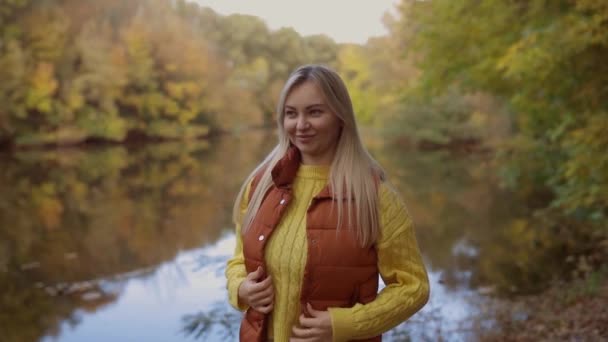 Atrakcyjna Blondynka Ciesząca Się Jesiennym Krajobrazem Dziewczyna Stoi Pobliżu Parku — Wideo stockowe