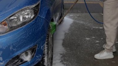 Oto yıkamadaki kadınlar arabayı fırçayla yıkarlar.. 