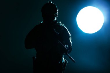 Muharebe üniformalı asker elinde Özel Harekat Kuvvetleri Saldırı Tüfeği tutuyordu. Gece, ay ışığıyla aydınlatılıyordu.