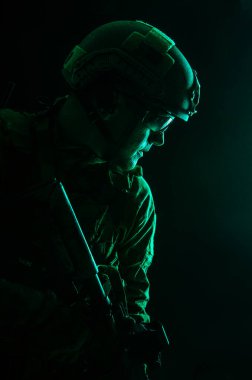 Özel Kuvvetler asker üniformaları silahlarla, portre siyah arka plan üzerine Studio kontur arka ışık vurdu
