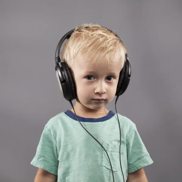 Menino sério com fones de ouvido — Fotografia de Stock