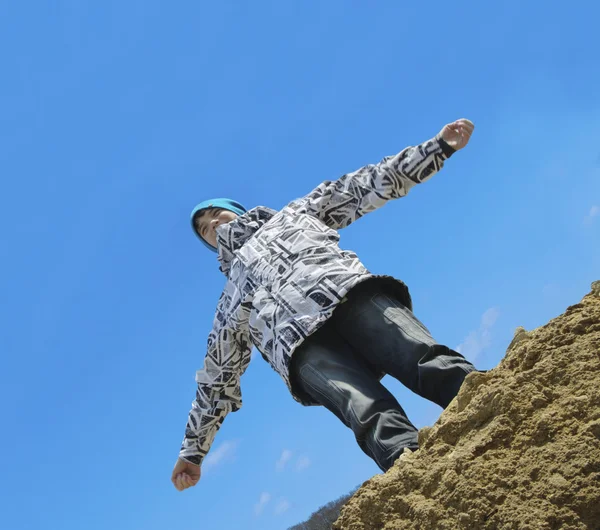 Young man flying above a rock — Stock Photo, Image