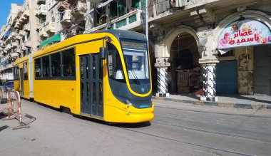 Alexandria, Egypt-A yellow Alexandria, Egypt tram with a blue sky and clouds in the background. Alexandria Egipt 06.12.2021