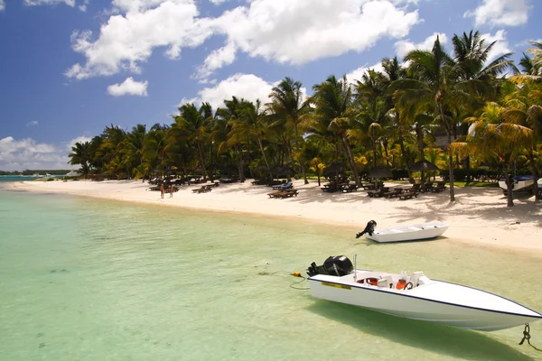 Piccola barca di fronte ad una spiaggia tropicale — Foto Stock