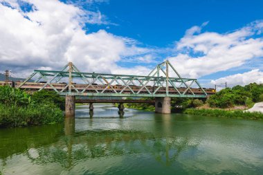 Tren, Yilan, Tayvan 'daki Dongshan Nehri Eko Parkı' ndaki demir köprüden geçiyor.