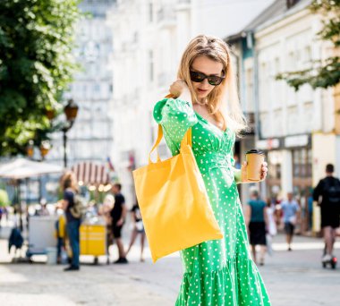 Şehrin arka planında sarı keten çantalı güzel bir kadın..