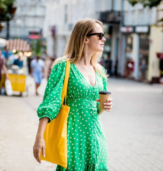 도시의 배경에 노란 아마포 가방을 들고 있는 아름다운 처녀. — 스톡 사진
