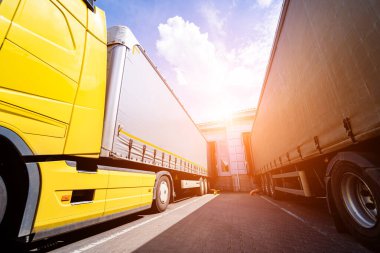 Depoya yakın büyük kamyonlar mavi gökyüzü arkaplanına karşı