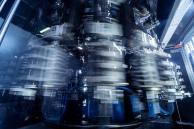 Modern içecek fabrikasında otomatik doldurma makinesi plastik PET şişelerine su doldurur.