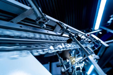 Modern içecek fabrikasında otomatik doldurma makinesi plastik PET şişelerine su doldurur.