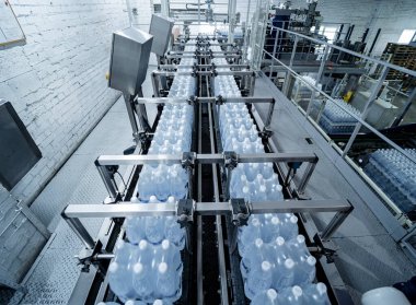 İçecek fabrikasında ambalaj hattı için modern bağlama ve taşıma makinesi.