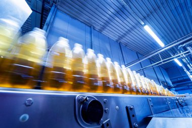 Modern bir içecek fabrikasında meyve suyu veya su için şişeli taşıyıcı bant