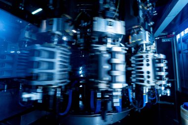 Modern içecek fabrikasında otomatik doldurma makinesi plastik PET şişelerine su doldurur.