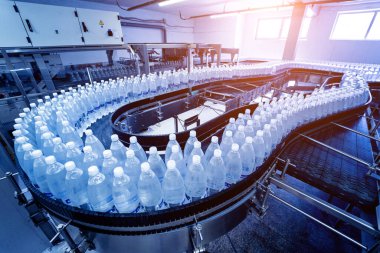 Modern bir içecek fabrikasında içme suyu şişeleriyle taşıma bandı..