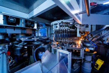 Modern içecek fabrikasında otomatik doldurma makinesi plastik PET şişelerine su doldurur.