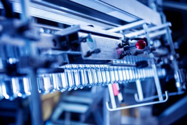 Modern içecek fabrikasında otomatik doldurma makinesi plastik PET şişelerine su doldurur.