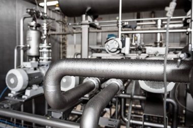 Fıçı ve boruları olan bir içecek fabrikasının modern iç mekanı.