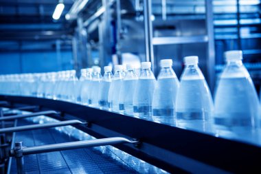 Modern bir içecek fabrikasında içme suyu şişeleriyle taşıma bandı..