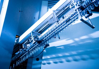 Modern içecek fabrikasında otomatik doldurma makinesi plastik PET şişelerine su doldurur.