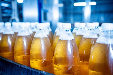 Modern bir içecek fabrikasında meyve suyu veya su için şişeli taşıyıcı bant