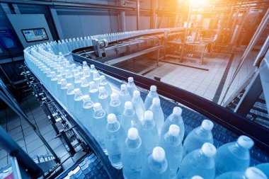 Modern bir içecek fabrikasında içme suyu şişeleriyle taşıma bandı..