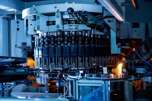 Máquina automática de llenado vierte agua en botellas de plástico PET en planta de bebidas moderna. —  Fotos de Stock