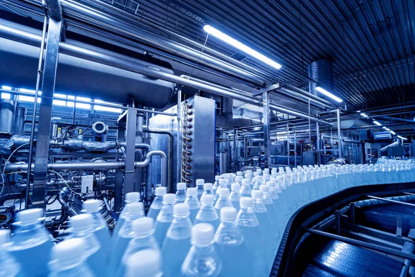 Taśma transportująca z butelkami wody pitnej w nowoczesnej fabryce napojów. — Zdjęcie stockowe