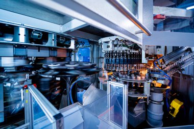 Modern içecek fabrikasında otomatik doldurma makinesi plastik PET şişelerine su doldurur.